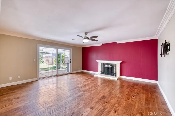 Living room with cozy fireplace, ceiling fan and easy back yard access.
