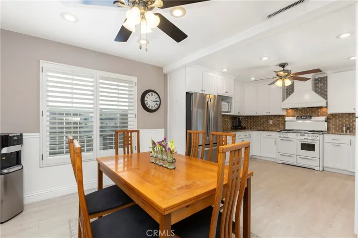 Updated kitchen with white cabinets, granite counters, farmhouse sink and custom tile backsplash