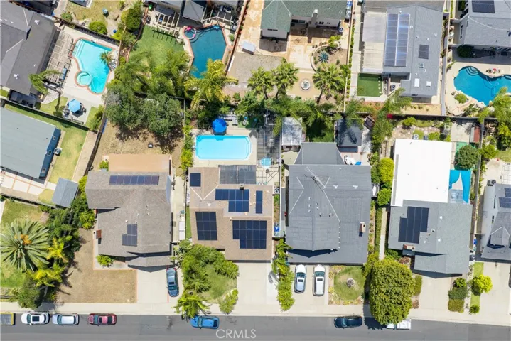 Top down view from drone looking a the home with solar panels and swimming pool.