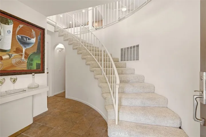 Entry with Spiral Staircase leading to upstairs living area and both bedrooms wile lower hall meanders to lower bedroom or the wine cellar