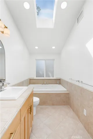 Primary bathroom looking towards 6' jetted tub and frosted window.