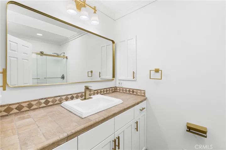 Family bathroom with oversized kitchen cabinets and tumbled turkish stone flooring and counter.