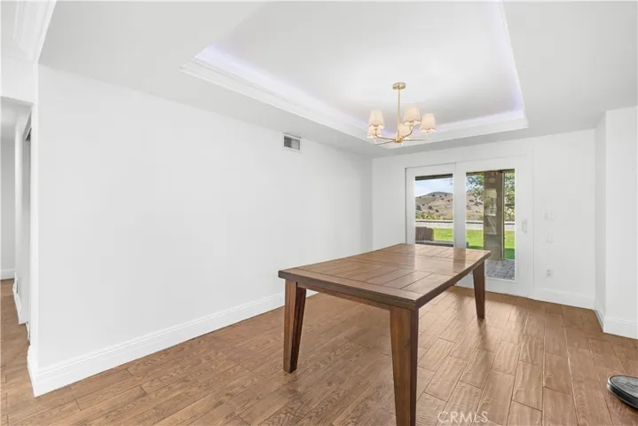 Dining room with tray ceiling, chandelier, and hidden rope accent lighting.  The sliding door leads to the covered patio and offers great mountain views.