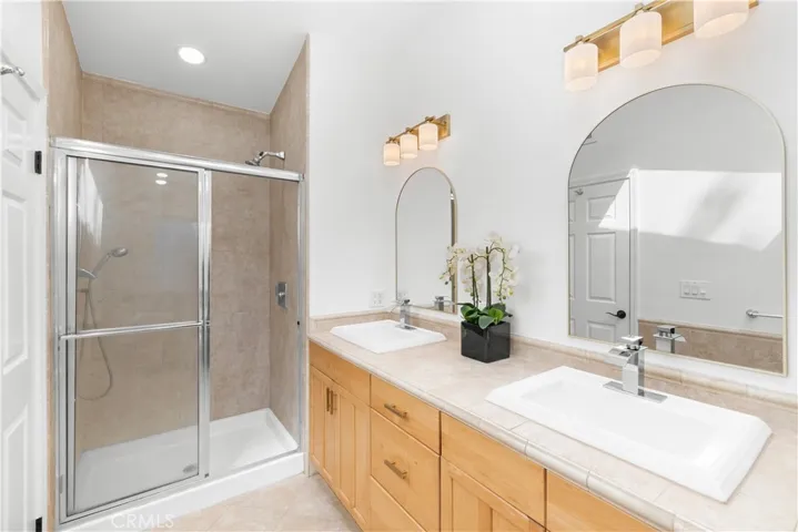 Primary bathroom with overside kitchen cabinetry for taller deeper counters.  Walk-in shower with two shower heads.