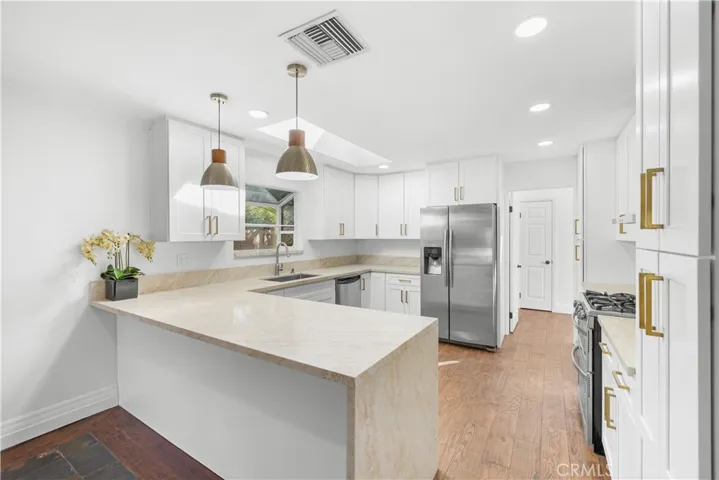 Very bright kitchen with 8' breakfast bar, pendant lights, recessed LED lights, and skylight.