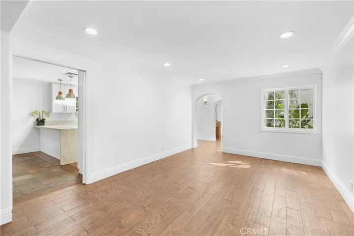 Living room with arch to foyer and window to atrium.