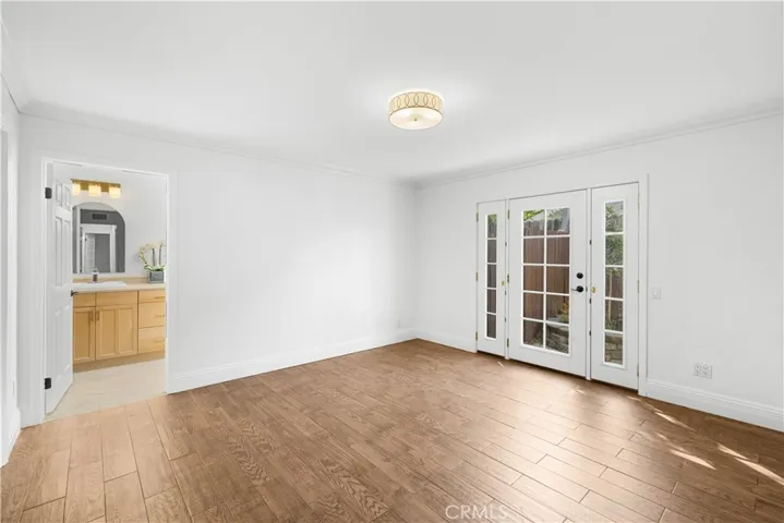Primary bedroom with glass door to private side yard.  Side lights open for air circulation  with screens.