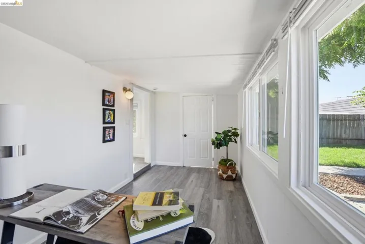 Bright interior space featuring wood-finish flooring, white walls, and multiple windows