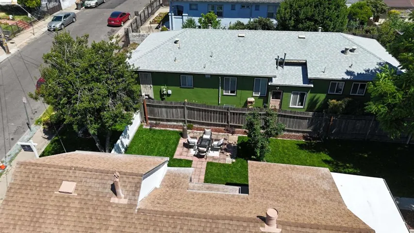 Expansive green backyard featuring a central patio area and perimeter fencing