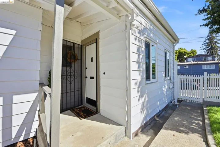 White siding exterior with multiple windows, a concrete entryway, and a white picket​​‌​​​​‌​​‌‌​​‌​​​‌‌​​​‌​​‌‌​​‌‌​​‌‌​​​​ fence