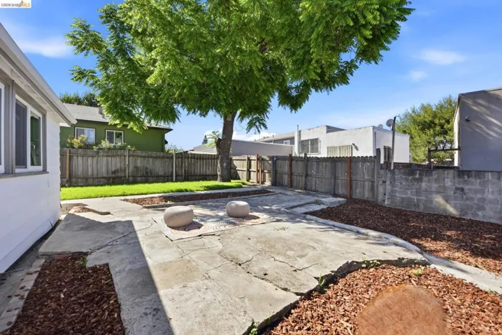 Expansive outdoor area featuring varied concrete paving and wood chip landscaping