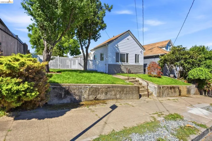 Light blue siding exterior with a partial stone foundation