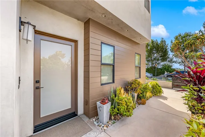 Lush landscaping and a welcoming approach lead to a stunning glass entry.
