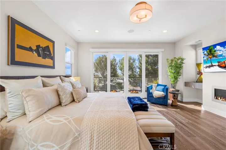 Luxurious primary suite offers a fireplace, private balcony, designer lighting, and a spa inspired en-suite bath, with a perfectly designed walk-in closet. Motorized shades provide effortless privacy and light control.