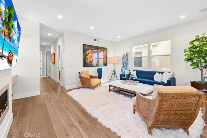 Light-filled family room features a cozy fireplace, wall-to-wall windows and an inviting sitting area at the top of the stairs