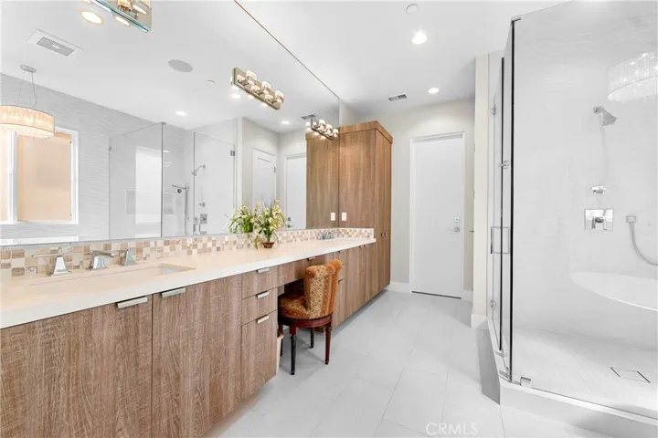 Spa-inspired primary bath showcases a Victoria + Albert soaking tub, seamless glass shower, designer lighting and impeccable finishes throughout.