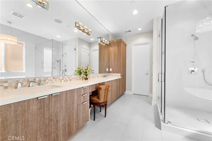 Spa-inspired primary bath showcases a Victoria + Albert soaking tub, seamless glass shower, designer lighting and impeccable finishes throughout.