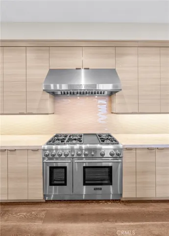 Thermador Appliances. Gourmet kitchen features a Thermador 6-burner range with grill, double ovens, and a center island with a prep sink, built-in microwave and wine fridge.