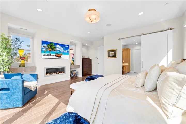 Luxurious primary suite offers a fireplace, private balcony, designer lighting, and a spa inspired en-suite bath, with a perfectly designed walk-in closet. Motorized shades provide effortless privacy and light control.