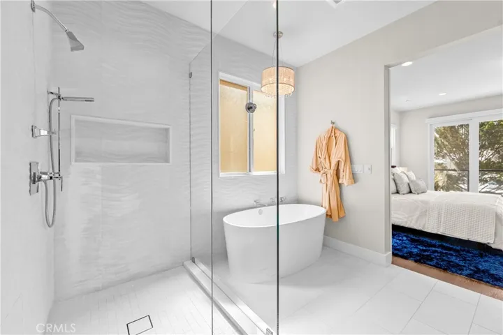 Spa-inspired primary bath showcases a Victoria + Albert soaking tub, seamless glass shower, designer lighting and impeccable finishes throughout.