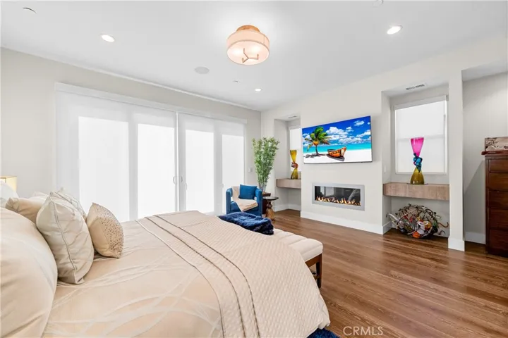 Luxurious primary suite offers a fireplace, private balcony, designer lighting, and a spa inspired en-suite bath, with a perfectly designed walk-in closet. Motorized shades provide effortless privacy and light control.
