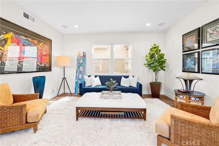 Light-filled family room features a cozy fireplace, wall-to-wall windows and an inviting sitting area at the top of the stairs