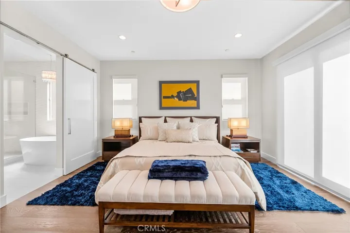 Luxurious primary suite offers a fireplace, private balcony, designer lighting, and a spa inspired en-suite bath, with a perfectly designed walk-in closet. Motorized shades provide effortless privacy and light control.