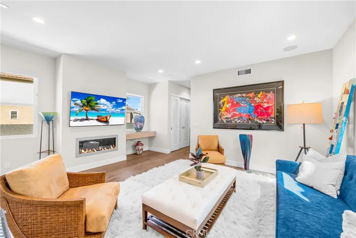 Light-filled family room features a cozy fireplace, wall-to-wall windows and an inviting sitting area at the top of the stairs