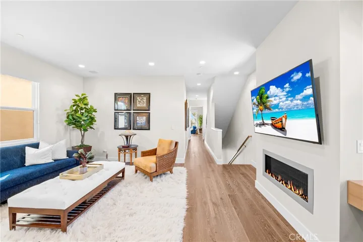Light-filled family room features a cozy fireplace, wall-to-wall windows and an inviting sitting area at the top of the stairs