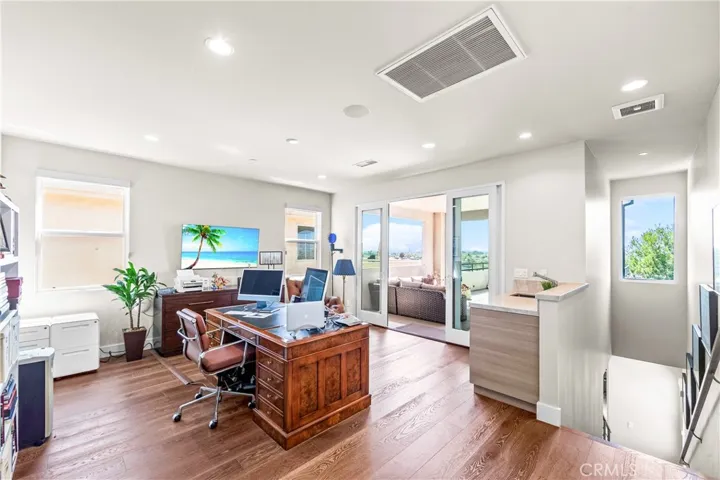 Versatile third-floor loft features walls of windows, a private bath, built -in beverage center with sink and refrigerator, and a view terrace perfect for a home office, guest suite, media room or creative retreat