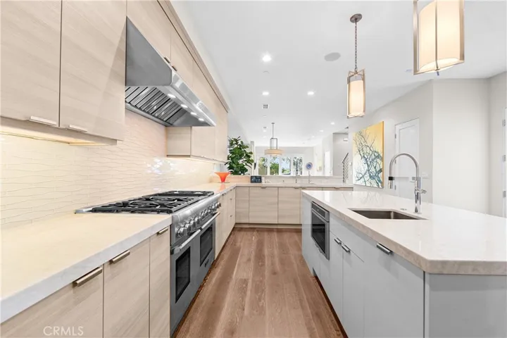 Gourmet kitchen features a Thermador 6-burner range with grill, double ovens, and a center island with a prep sink, built-in microwave and wine fridge.