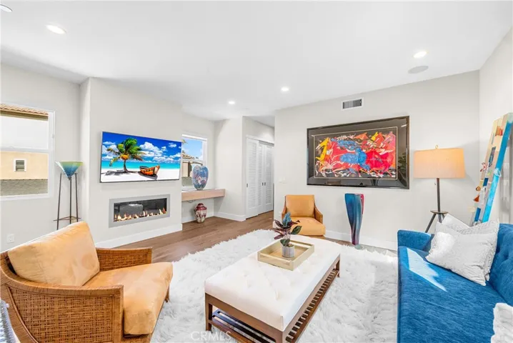 Light-filled family room features a cozy fireplace, wall-to-wall windows and an inviting sitting area at the top of the stairs