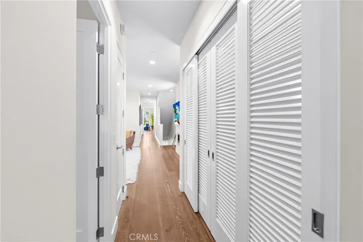 Thoughtfully designed laundry center features custom cabinetry utility sink, folding counter, hanging bar, and louvered doors that conceal the space when not in use.