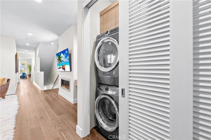 Thoughtfully designed laundry center features custom cabinetry utility sink, folding counter, hanging bar, and louvered doors that conceal the space when not in use.