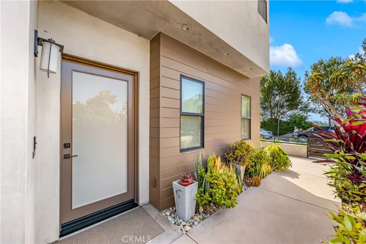 Lush landscaping and a welcoming approach lead to a stunning glass entry.