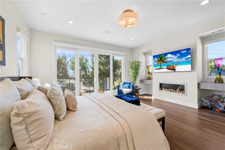 Luxurious primary suite offers a fireplace, private balcony, designer lighting, and a spa inspired en-suite bath, with a perfectly designed walk-in closet. Motorized shades provide effortless privacy and light control.