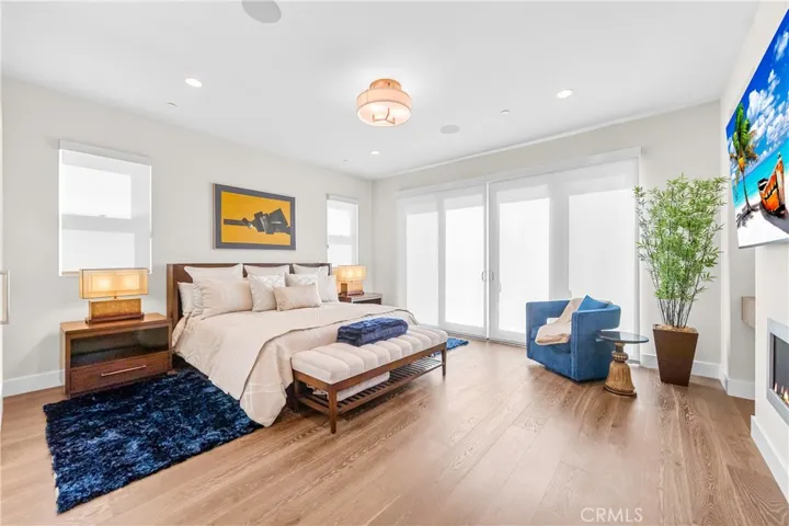 Luxurious primary suite offers a fireplace, private balcony, designer lighting, and a spa inspired en-suite bath, with a perfectly designed walk-in closet. Motorized shades provide effortless privacy and light control.