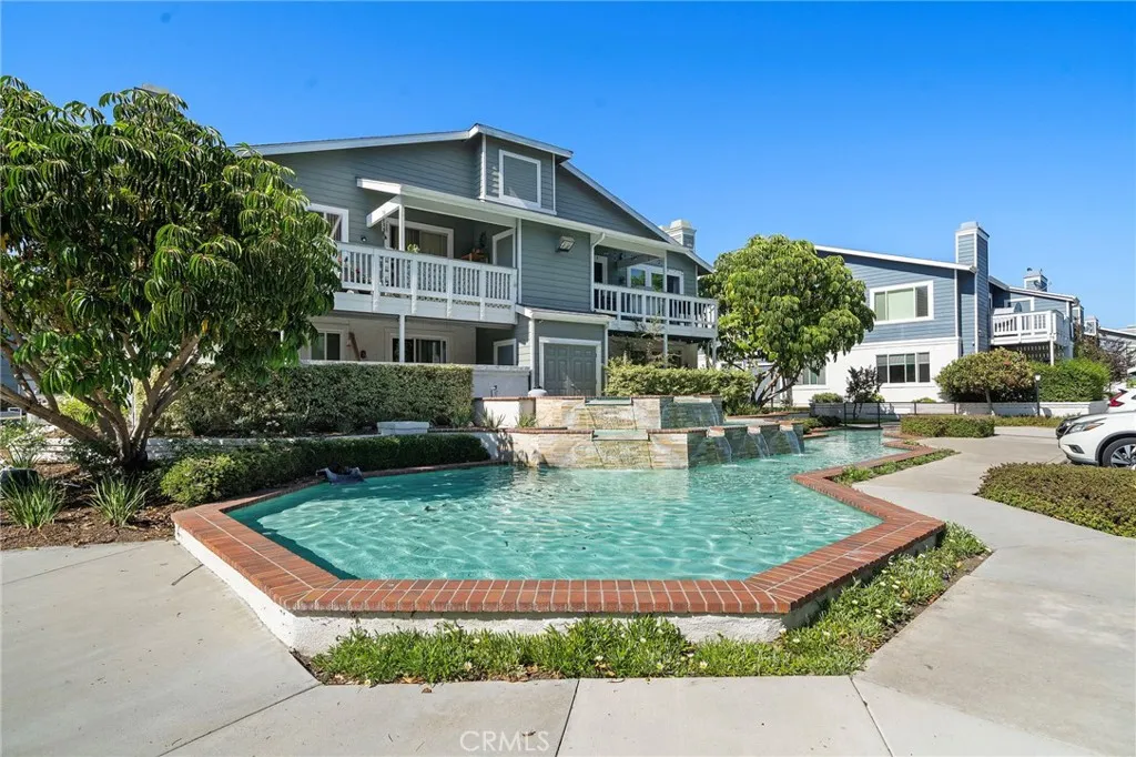 Community Amenities: Tranquil community water feature surrounded by lush landscaping, creating a peaceful and inviting neighborhood setting.