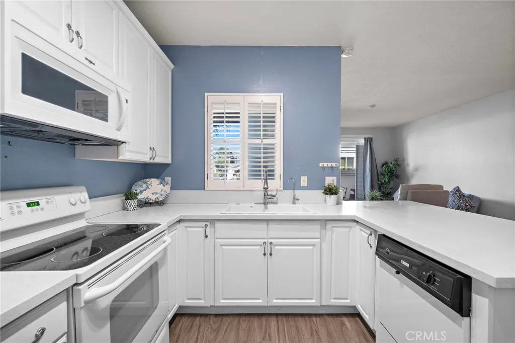 Kitchen: Open-concept kitchen with quartz countertops, white cabinetry, and a functional layout overlooking the living area.