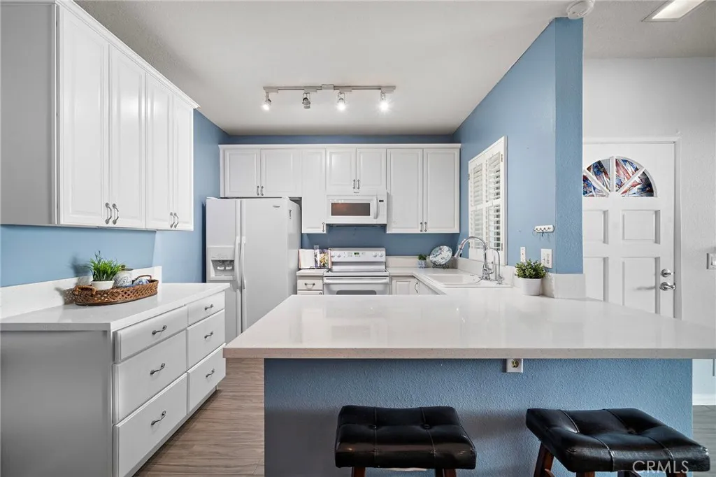 Kitchen: Bright, open kitchen featuring quartz countertops, a breakfast bar, and ample cabinet space.