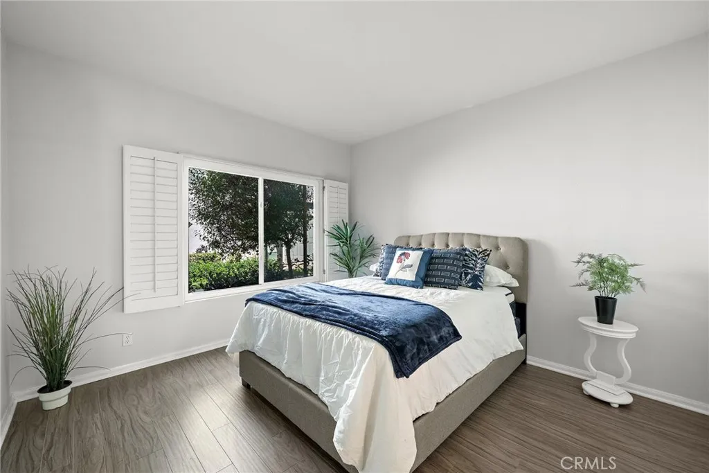 Bedroom: Spacious bedroom with large windows, plantation shutters, and abundant natural light.