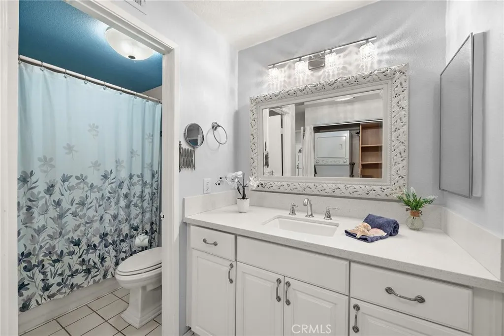 Bathroom: Updated bathroom featuring a quartz vanity, oversized framed mirror, and tub/shower combination.