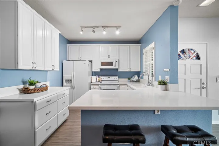 Kitchen: Bright, open kitchen featuring quartz countertops, a breakfast bar, and ample cabinet space.