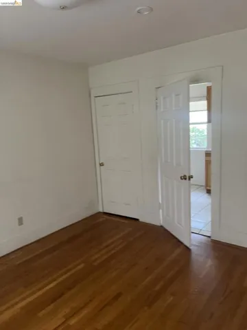 Hardwood flooring throughout, featuring a five-panel interior door and an adjacent closet