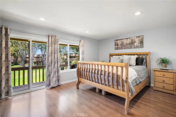 Primary w/ sliding glass doors to balcony view of beautiful greenbelt