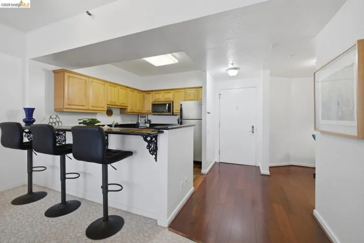 Kitchen with wood cabinetry, black countertops, and stainless steel appliances