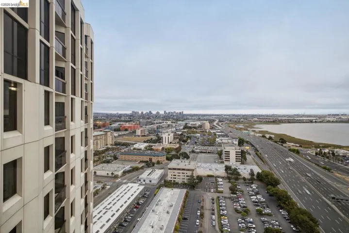 Modern high-rise exterior with multiple balconies, featuring a cityscape backdrop