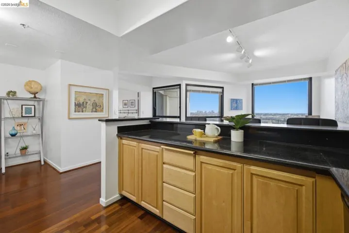 Kitchenette featuring dark granite-style countertops and light wood-finish cabinetry