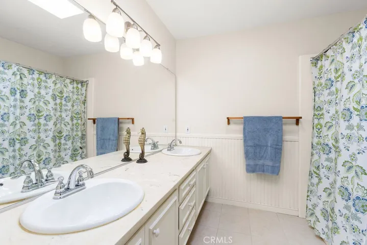 Upper guest bathroom with dual vanity & full tub.