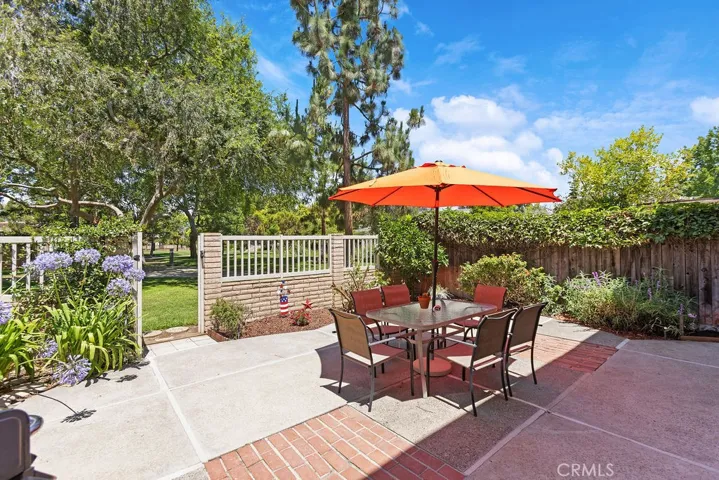 Spacious back patio with brick inlay, lush landscaping and direct access to the park.
